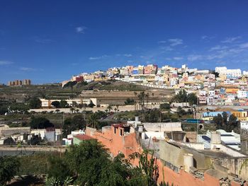 Buildings in town against blue sky