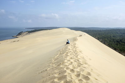 Side view of person sitting on beach