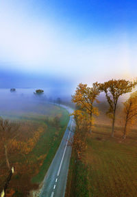 Aerial view of road amidst trees against sky