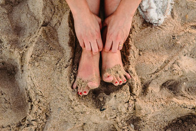 Low section of woman legs on sand