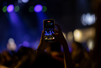Recording a concert with mobile phone, silhouette of hands with smartphone