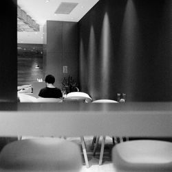 Rear view of woman sitting on chair at home