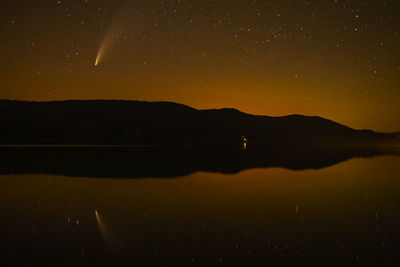 Scenic view of lake against sky at night