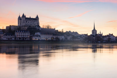 Buildings at waterfront during sunset