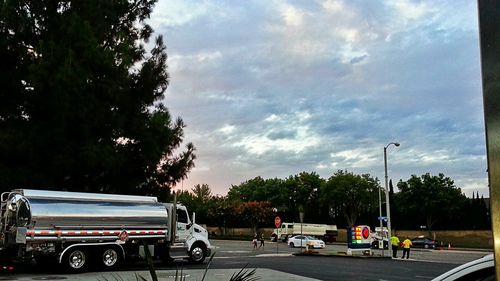 Cars parked in parking lot against cloudy sky