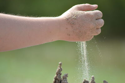 Cropped hand making sandcastle