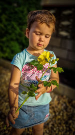 Girl holding flower against blurred background