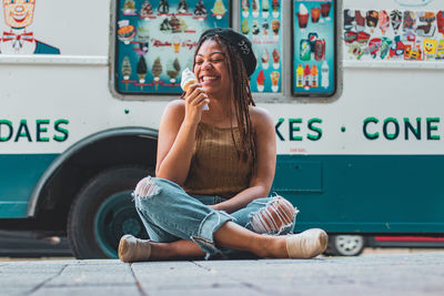 Full length of a young woman sitting outdoors