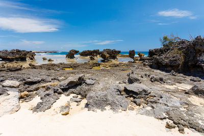 Rocks on beach against sky