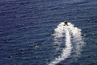 Distant view of people on jet boat at sea