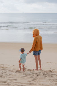 Rear view of boy running at beach