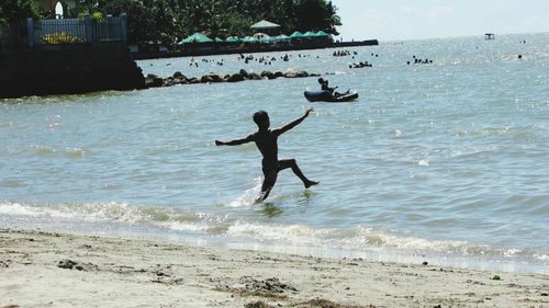 Man surfing in sea against sky