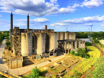 Factory against cloudy sky