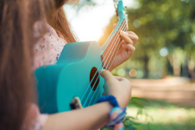 Midsection of woman playing guitar