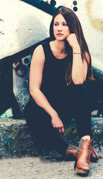 Portrait of a young woman sitting outdoors