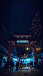 People on illuminated building at night