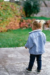 Rear view of woman standing on footpath