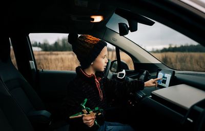 Woman using mobile phone while sitting in car