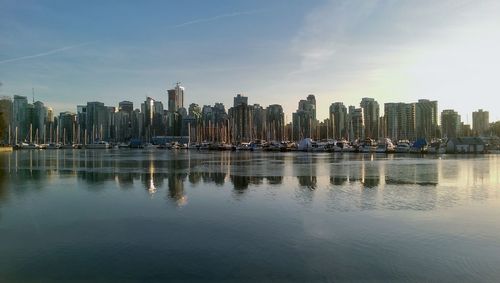 City at waterfront against cloudy sky