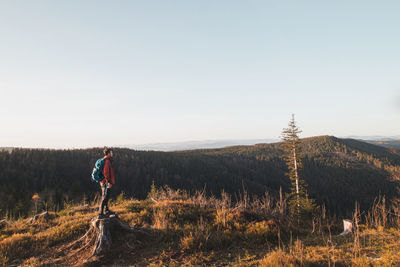 Active hiker enjoys the feeling of reaching the top of the mountain at sunrise. hiker is enlightened