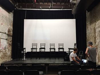 Men discussing on stage in theater