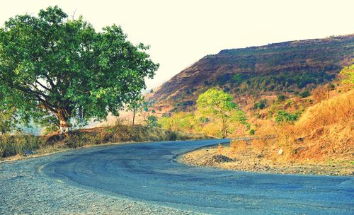 Empty road along countryside landscape