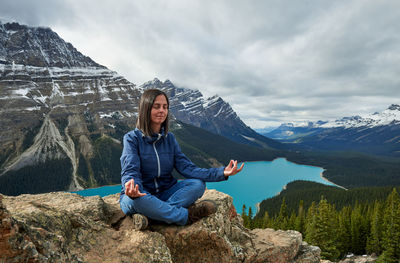 Relaxed woman doing yoga in peyto lake, banff national park