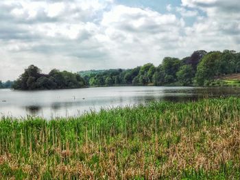 Scenic view of lake against cloudy sky