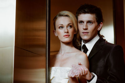 Close-up of couple holding hands against wall