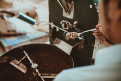 Cropped image of roasting coffee beans in cafe