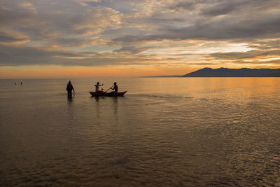 Young adults having fun at the beach against a golden sunset, kande beach, lake malawi, malawi
