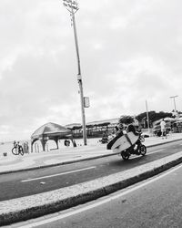 Cars on road against cloudy sky