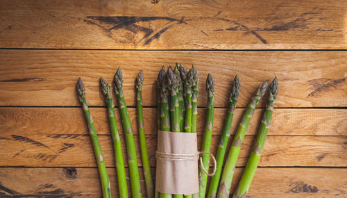 Fresh green asparagus on wooden background, top view, text space, copy space