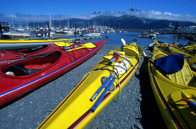 Sailboats moored in sea against sky in city