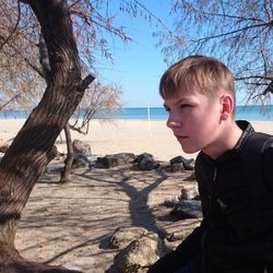 Boy looking away on land against sky