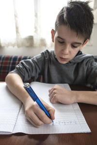 Midsection of boy with text on table