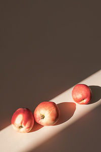 Peaches in sunlight. minimalism, trendy still life with shadow.