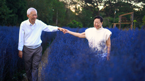 Full length of a young man standing against trees