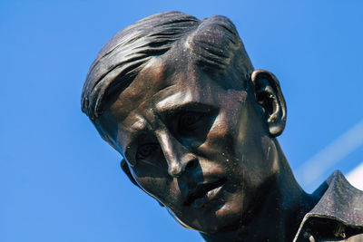 Low angle view of statue against clear blue sky