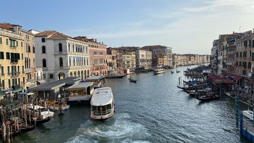 Boats in canal amidst buildings in city