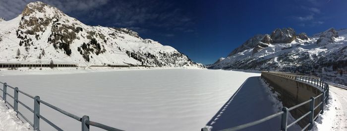 Panoramic view of snowcapped mountains by lake against sky