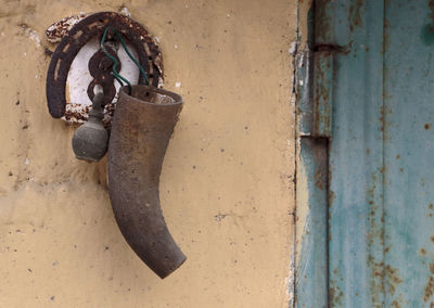 Old rusty metal horseshoe and bell on wall