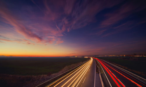 Light trails on highway at sunset