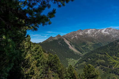 Scenic view of mountains against blue sky