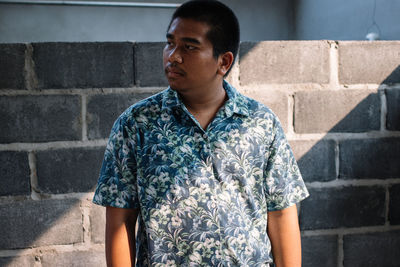 Young man standing against wall