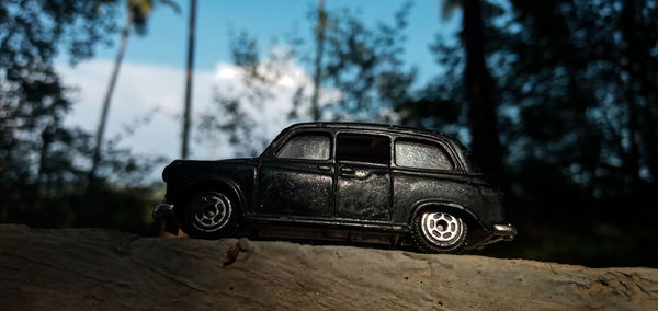 Close-up of abandoned car on field