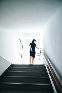 Low angle view of woman standing on staircase