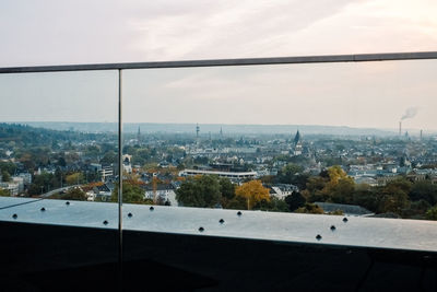 High angle view of buildings against sky seen through glass window