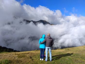 People standing on mountain against sky