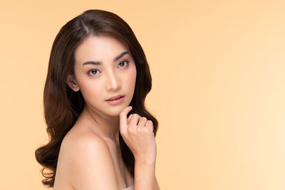 Portrait of beautiful young woman against gray background
